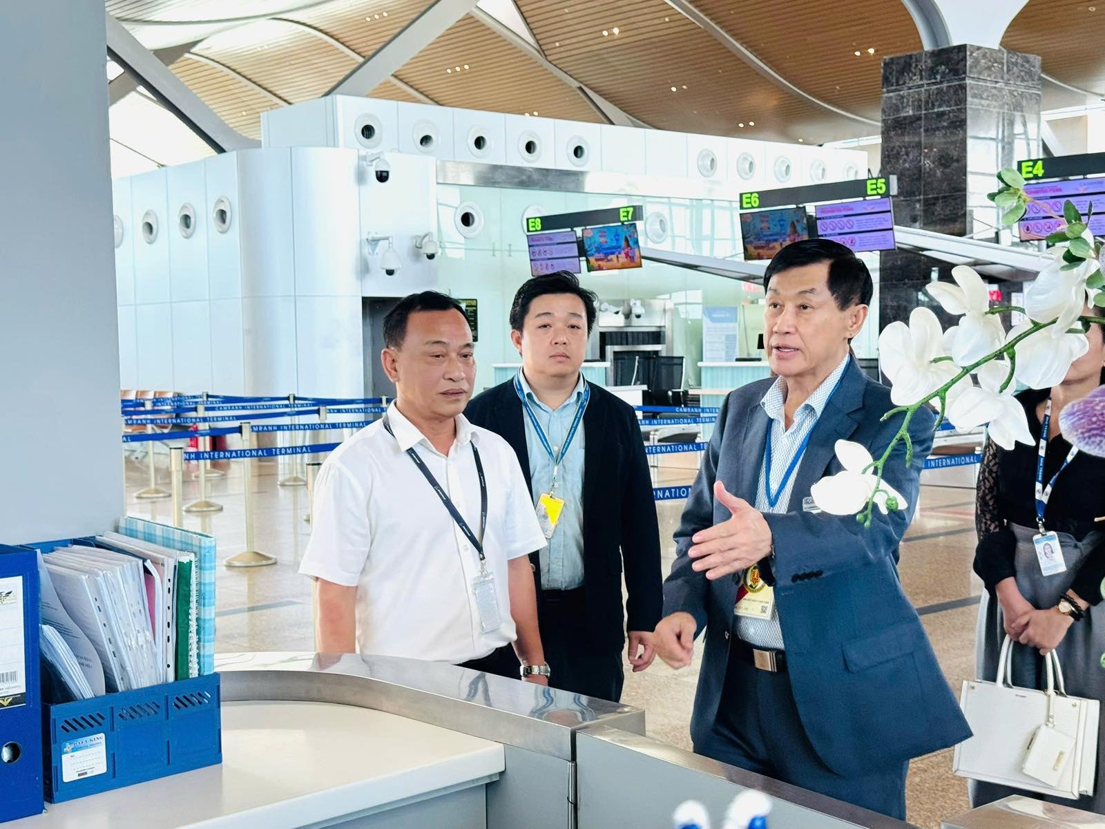 Dấu ấn của “vua hàng hiệu” Johnathan Hạnh Nguyễn tại nhà ga quốc tế Cam Ranh- Ảnh 3. A group of men standing in a lobby Description automatically generated