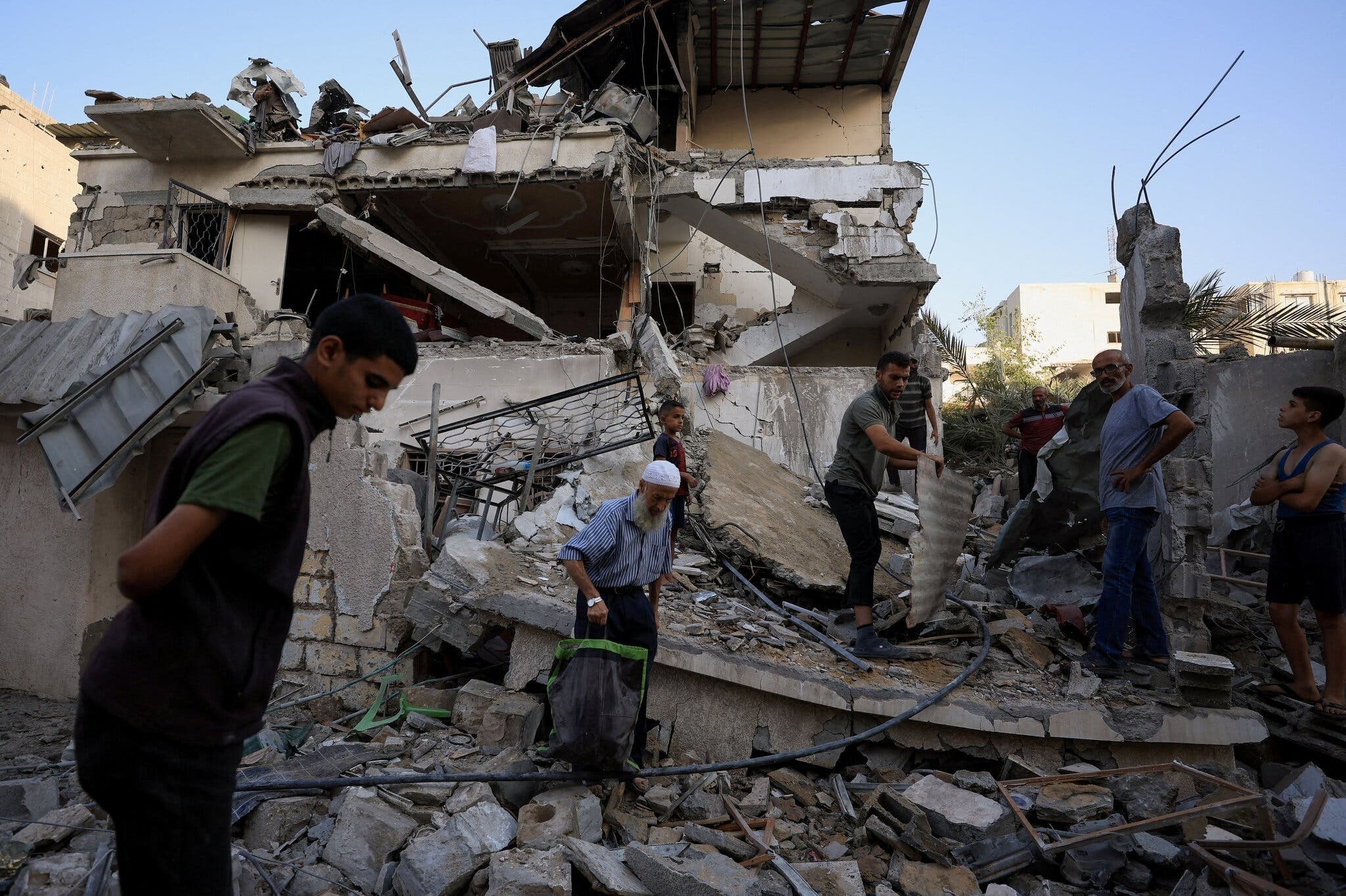 Người dân Palestine kiểm tra hiện trường vụ không kích của Israel vào một ngôi nhà ở thành phố Gaza trong đêm.