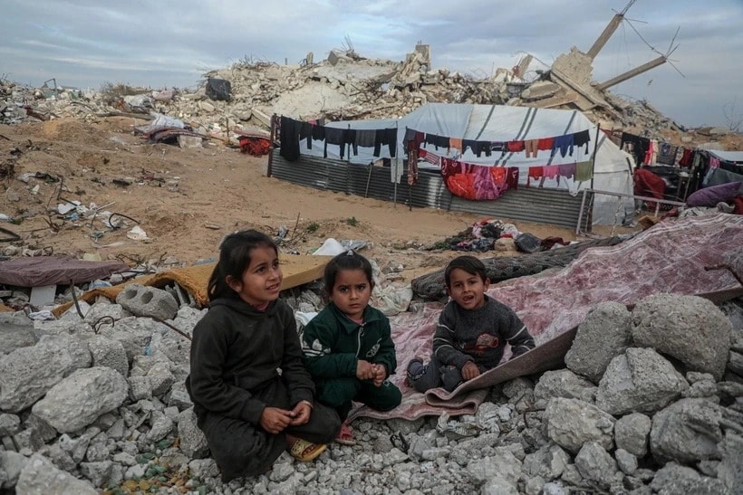 Các em nhỏ ngồi trên đống đổ nát của ngôi nhà bị phá hủy do xung đột ở Gaza. (Ảnh: THX)