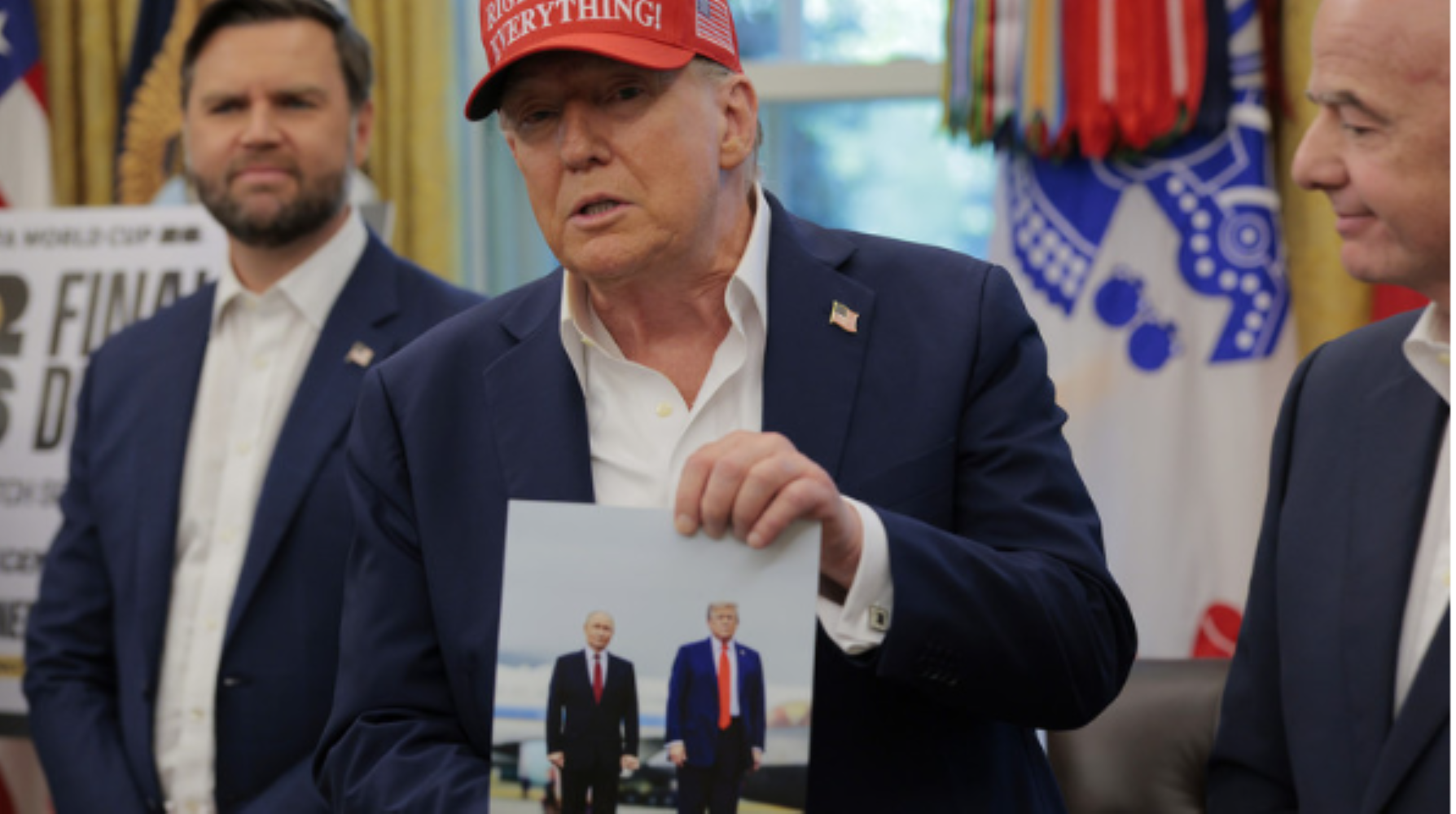Tổng thống Donald Trump cầm bức ảnh chụp ông với Tổng thống Nga Vladimir Putin ở Alaska. (Ảnh: Getty)