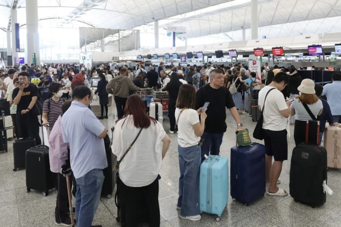 Hành khách ngồi chờ tại sảnh khởi hành sân bay quốc tế Hong Kong ngày 23/9, sau khi nhiều chuyến bay bị hủy vì siêu bão Ragasa. Ảnh: SCMP