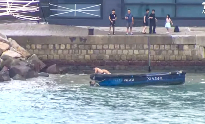 Thuyền tuần tra của biển của Hong Kong cứu cặp vợ chồng và người con trai 5 tuổi ở quận Chai Wan, Hong Kong ra đê chắn sóng xem bão Rasaga và bị cuốn xuống biển, chiều 23/9. Ảnh: Jimunews