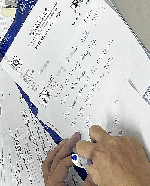 Nhân viên y tế phải ghi bằng tay thay vì gõ máy tính, do hệ thống mạng bị lỗi tại Bệnh viện Nhân dân Gia Định, sáng 24/9. Ảnh: Khánh Hồng