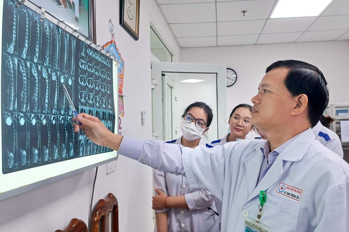Bác sĩ Thân Trọng Vũ đọc kết quả chụp CT Scan ngực để chẩn đoán bệnh và chỉ định phẫu thuật cho bệnh nhân. Ảnh: Thu Phương