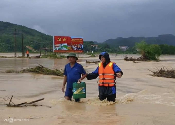 Người dân lội qua con đường ngập sâu ở xã Vạn Xuân, sáng 27/9. Ảnh: Lam Sơn