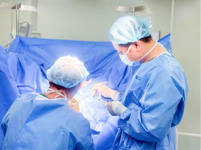 Bác sĩ Biên (phải) đang phẫu thuật cắt trĩ cho chị Thanh. Ảnh: Bệnh viện Đa khoa Tâm Anh