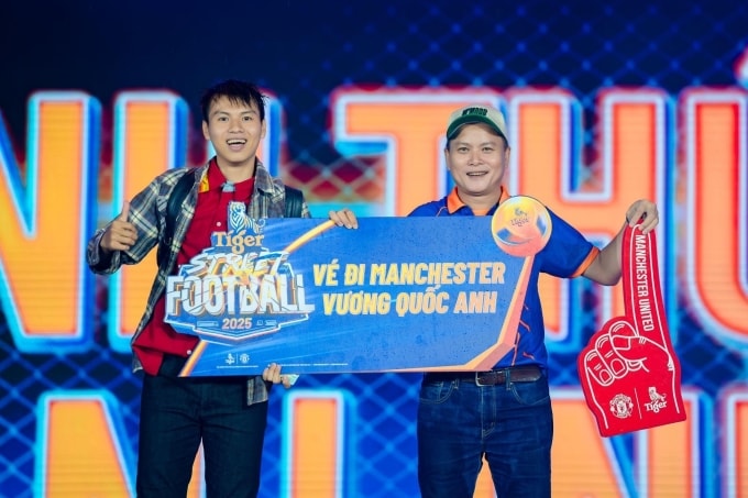Tại vòng chung kết khu vực miền Trung, anh Nguyễn Bình Nhân (trái) nhận tấm vé dành cho khán giả may mắn đến Manchester, Anh tháng 1/2026. Ảnh: Tiger Beer
