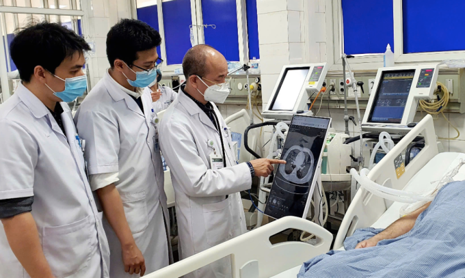 Các bác sĩ Bệnh viện Bạch Mai kiểm tra phim chụp của bệnh nhân hiển thị trên bệnh án điện tử ngay tại giường bệnh. Ảnh:Nguyên Hà