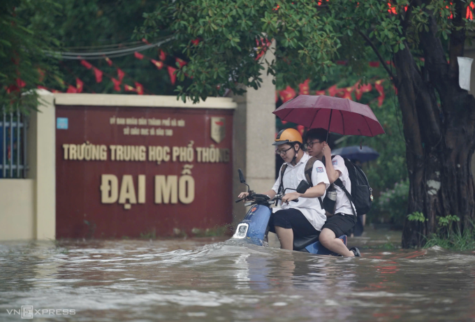 Học sinh Hà Nội về nhà giữa biển nước khi tan học trưa 30/9. Ảnh: Hoàng Giang