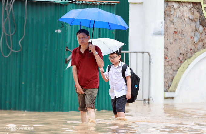 Học sinh lội qua chỗ ngập ở Cầu Giấy, Hà Nội, trong trận mưa, gây ngập cuối tháng 8/2025. Ảnh: Đức Đồng