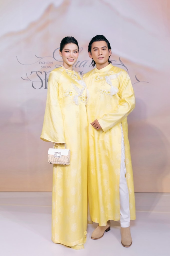Trang phục đính họa tiết chim ở ngực tạo điểm nhấn. Phương Trinh Jolie phối áo dài với vòng cổ ngọc trai, xách túi phong cách cổ điển. Tại show, cặp sao còn tham gia trình diễn trên sàn runway.