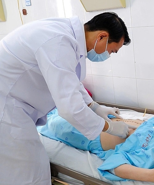 Bác sĩ kiểm tra vết mổ cho bệnh nhân. Ảnh: Bệnh viện cung cấp