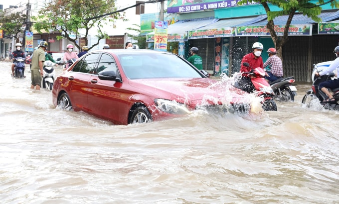 Chiếc Mercedes phóng qua vùng nước ngập, đường Cách Mạng Tháng Tám, thành phố Cần Thơ. Ảnh: Cửu Long - Nguyên Anh