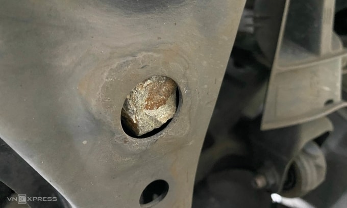 Đá cuội kẹt trong hệ treo của một mẫu sedan sau khi lội qua đường ngập. Ảnh: Hồ Tân