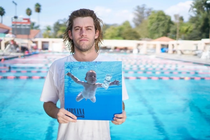 Spencer Elden cầm bìa album huyền thoại  Nevermind của ban nhạc Nirvana, sử dụng hình ảnh của chính anh khi mới 4 tháng tuổi. Ảnh: NYT