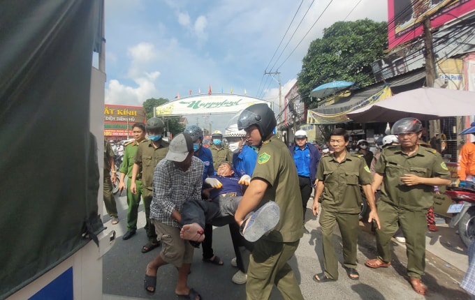 Công an xã đưa nạn nhân lên xe đi cấp cứu. Ảnh: Nam An