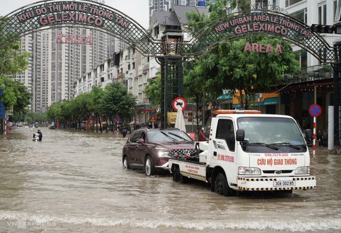Xe cứu hộ giao thông kéo ôtô qua đoạn ngập khu vực An Khánh, Hoài Đức. Ảnh: Hoàng Giang