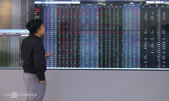 Nhà đầu tư đang theo dõi bảng điện tử tại trụ sở một công ty chứng khoán ở TP HCM. Ảnh: Quỳnh Trần