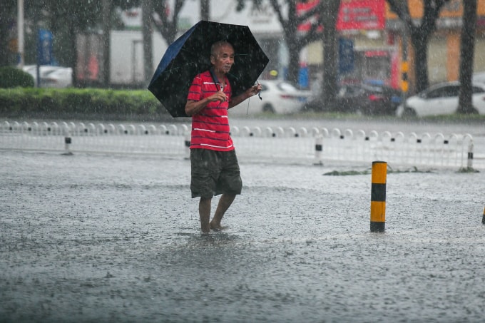 Người dân di chuyển trên đường ngập ở Hải Khẩu, Hải Nam ngày 5/10. Ảnh: VCG