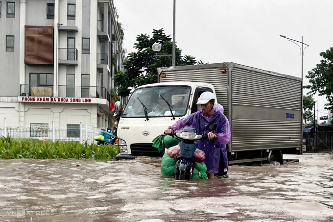 Người dân vất vả đi qua đoạn ngập sâu trước khu vực viện K, Tân Triều. Ảnh: Huy Mạnh