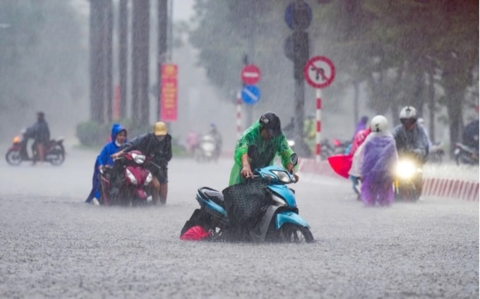 Trên phố Nguyễn Hoàng, nhiều phải dắt xe cuốc bộ dưới mưa to, nước dâng cao khoảng 0,4 m. Ảnh:Tùng Đinh