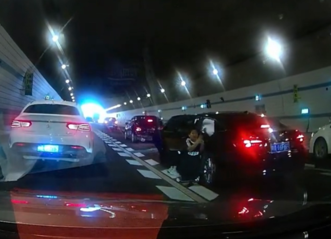 Hình ảnh cậu bé 10 tuổi ra khỏi ôtô, quỳ xuống đường và chắp tay xin mọi người cứu mẹ, tại đường hầm Thạch Môn Đường Sơn, thành phố Quảng Châu, tỉnh Quảng Đông, chiều 4/10. Ảnh: Sohu