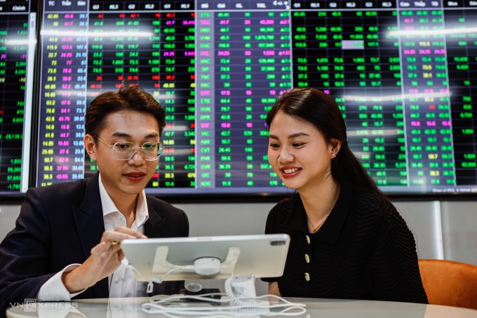 Nhà đầu tư đang quan sát bảng điện tử tại trụ sở một công ty chứng khoán ở TP HCM. Ảnh: An Khương