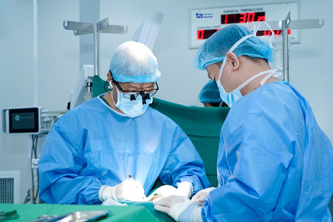 Bác sĩ Trông (trái) và bác sĩ Hiếu đang phẫu thuật cho bệnh nhân Hoàng. Ảnh: Bệnh viện cung cấp