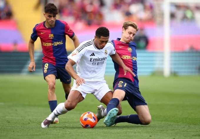 Frenkie de Jong (phải) tranh chấp với Jude Bellingham trong trận Barca thắng Real 4-3 trên sân Montjuic, Barcelona, Catalunya, Tây Ban Nha ngày 11/5/2025. Ảnh: Reuters