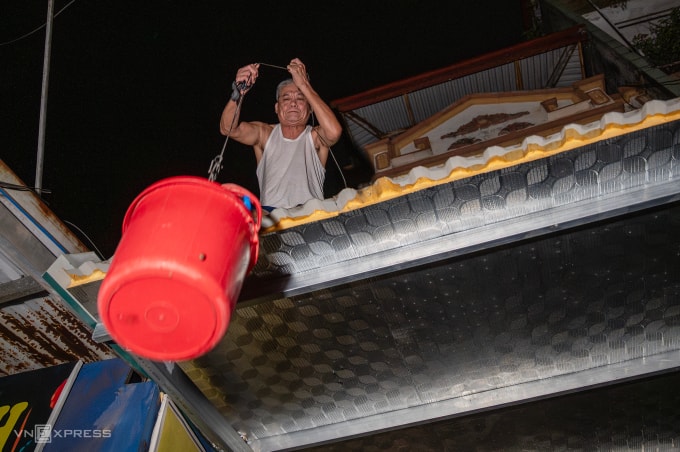 Người dân phường Quang Vinh, Thái Nguyên dùng xô nhận đồ tiếp tế đêm 8/10. Ảnh: Giang Huy