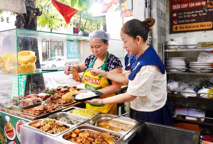 Bà Mai Thị Loan (trái) mẹ của chị Tiên, người tạo ra công thức các món ăn, thường xuyên đứng bếp để phụ giúp các con. Ảnh: Thái Anh