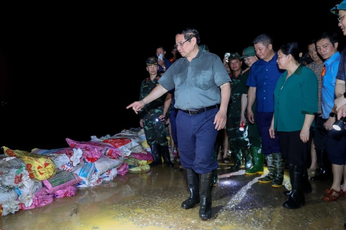 Thủ tướng Phạm Minh Chính kiểm tra công tác ứng phó với mưa lũ tại các xã Trung Giã, Đa Phúc, TP Hà Nội tối 9/10. Ảnh: Nhật Bắc