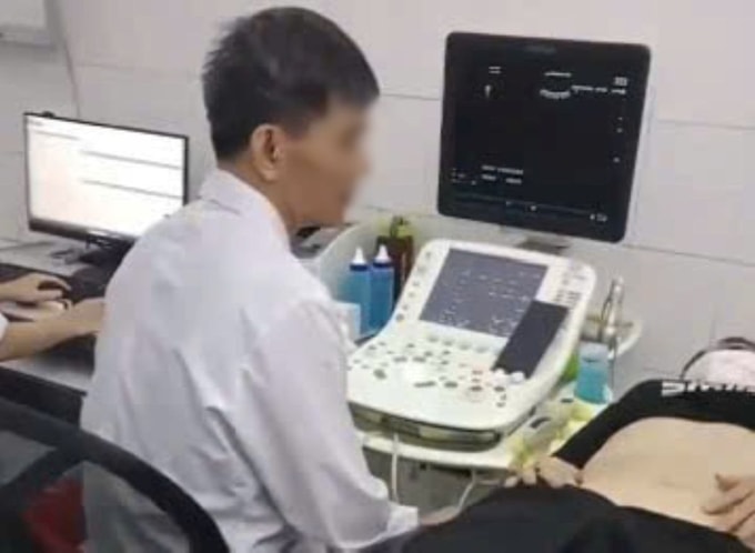 Bác sĩ Bệnh viện Đa khoa Thường Xuân bị phản ứng vì vừa siêu âm vừa xem bóng đá trên điện thoại. Ảnh cắt từ clip