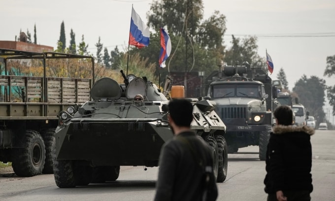Các tay súng Syria quan sát đoàn xe Nga tiến vào căn cứ Hmeimim hôm 16/12/2024. Ảnh: AP
