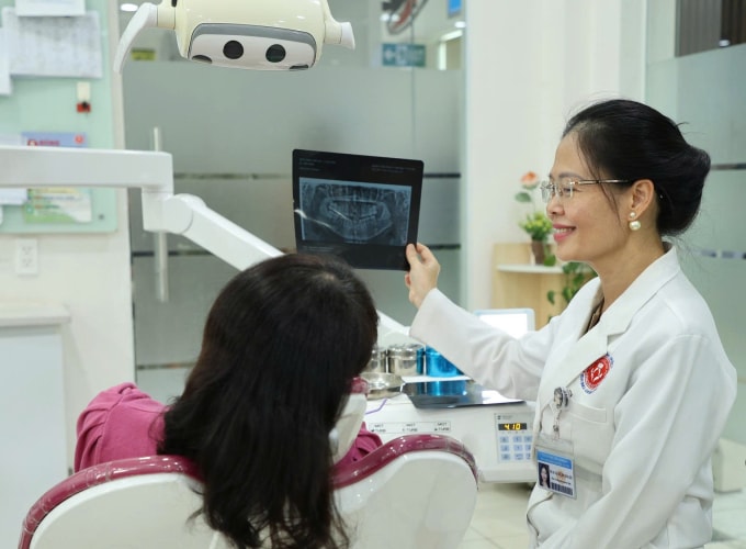 Bác sĩ tư vấn cho người bệnh trên phim chụp trước khi niềng răng. Ảnh: Bệnh viện cung cấp