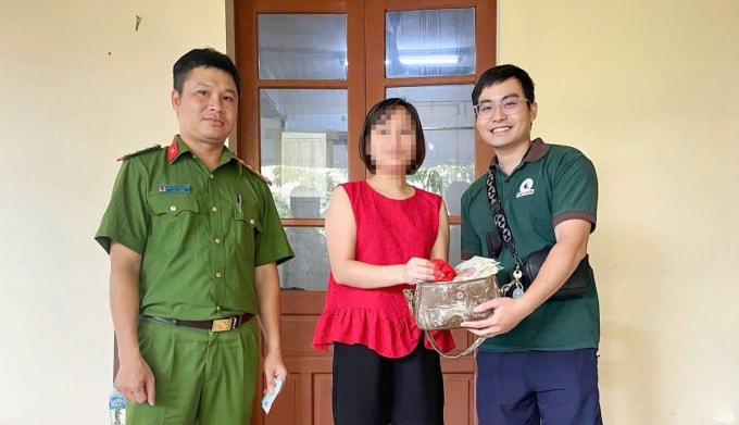 Anh Trung Kiên (đầu tiên từ phải sang) trao trả lại chiếc túi cho chị T (áo đỏ) tại công an phường Phan Đình Phùng, Thái Nguyên ngày 11/10. Ảnh: Công Minh