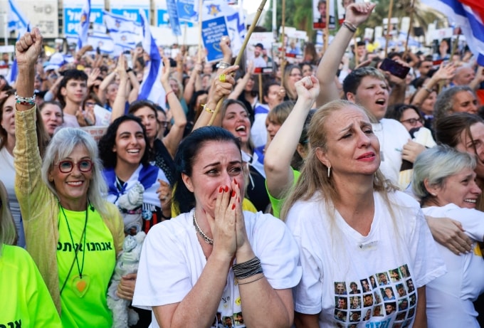 Người phụ nữ ôm mặt nghẹn ngào khi theo dõi thông tin về nhóm con tin đầu tiên được trao trả, tại Quảng trường Con tin ở Tel Aviv ngày 13/10. Ảnh: AFP