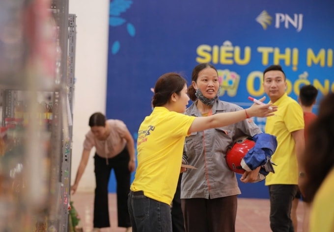 Tình nguyện viên PNJ hỗ trợ bà con mua sắm tại siêu thị 0 đồng. Ảnh: Việt Trung