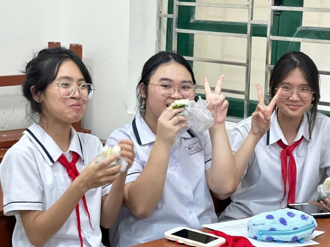 Học sinh THCS Hồng Bàng vui vẻ với bữa ăn bất ngờ ở trường trong ngày mưa lụt. Ảnh: Xuân Hoa
