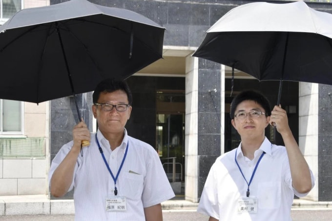 Hai quan chức Saitama dùng ô che nắng ở Nhật Bản. Ảnh: Kyodo