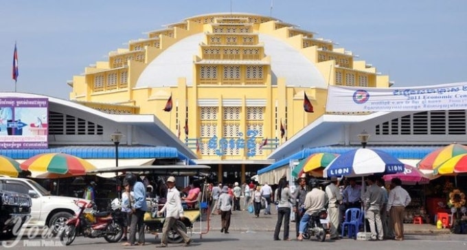 Cảnh sát đứng dưới những chiếc ô có chữ Lion bên ngoài chợ Phnom Penh. Ảnh: NVCC