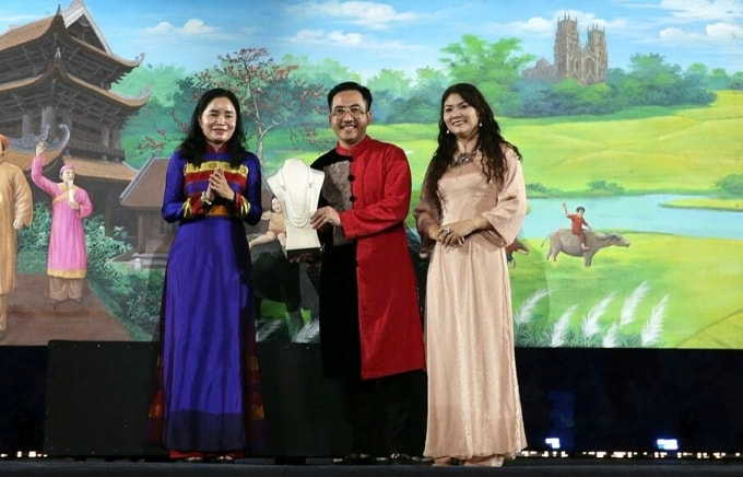 Thứ trưởng Bộ Văn hóa, Thể thao và Du lịch Trịnh Thị Thuỷ (trái) trao vật phẩm đấu giá tại Lễ hội Văn hoá Thế giới tại Hà Nội lần thứ nhất, ngày 11/10. Ảnh: Trần Huấn