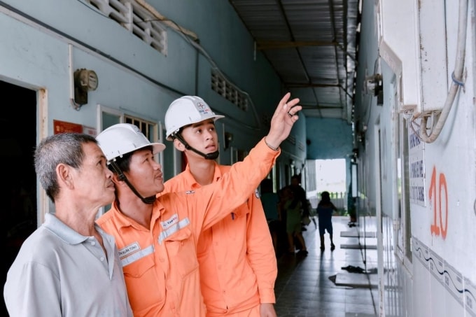 Nhân viên Công ty Điện lực An Giang tuyên truyền, hướng dẫn sử dụng điện an toàn cho người dân. Ảnh: EVNSPC