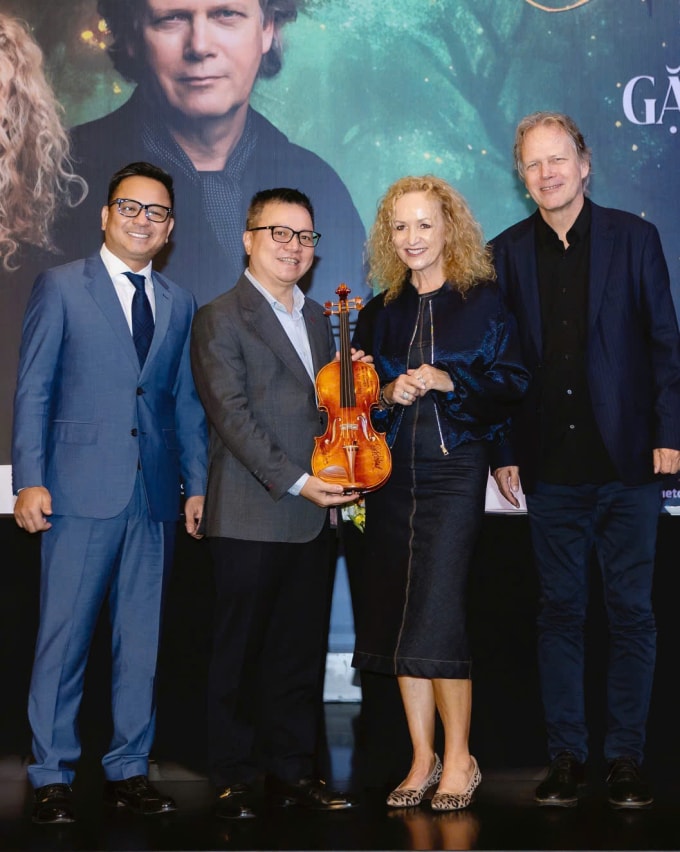 Nhóm nhạc tặng ông Lê Quốc Minh - Tổng biên tập báo Nhân Dân, đại diện ban tổ chức (thứ hai từ trái sang) một cây đàn làm kỷ niệm. Ảnh: Ban tổ chức cung cấp