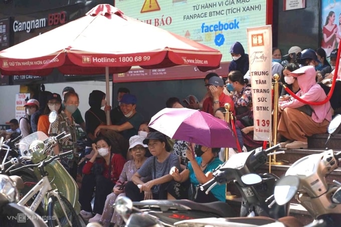 Người dân xếp hàng, ngồi chờ mua vàng trước cửa hàng Bảo Tín Minh Châu, 139 Cầu Giấy, sáng 17/10. Ảnh: Hoàng Giang