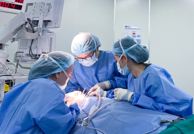 Giáo sư Chung Thủy (trái) đang cắt khối u, tái tạo vành tai cho bà An. Ảnh: Bệnh viện Đa khoa Tâm Anh