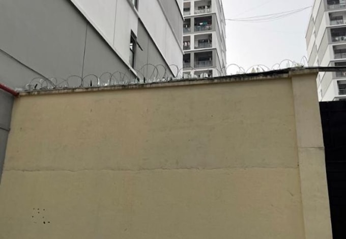 Bức tường với hàng rào dây thép gai và mảnh kính vỡ bao quanh một khu phức hợp ở Sihanoukville, Campuchia ngày 15/10. Ảnh: Hankook Ilbo