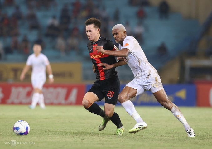 Nguyễn Hoàng Đức (trái) tranh chấp với Daniel Passira trong trận Ninh Bình thắng Hà Nội FC 2-1 ở vòng 7 V-League 2025-2026. Ảnh: Hoàng Huynh