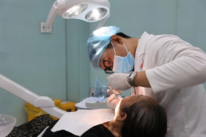 Bác sĩ Khoa Lão Nha, Bệnh viện Răng Hàm Mặt TP HCM, điều trị cho người cao tuổi. Ảnh: Bệnh viện cung cấp