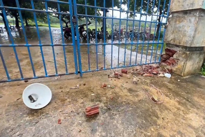 Trụ cổng trường bị sét đánh hư hỏng, bóng đèn (bên trái) rơi vỡ. Ảnh: Đông Sơn